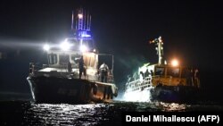 A border police ship pulls a vessel transporting migrants the port of Midia on the Black Sea coast on September 13.