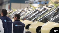 Инженеры франко-германской компании Eurocopter прогуливаются вдоль вертолетов