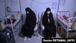 Mothers sit next to their babies receiving treatment for malnutrition at a Doctors Without Borders nutrition center in Herat.