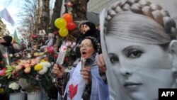 A supporter of Yulia Tymoshenko holds her portrait during a rally in front of the Kyiv 's prison as they mark her 51st birthday