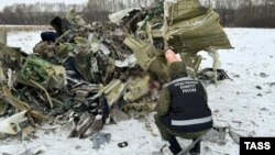 An investigator examines debris at the crash site of an Ilyushin Il-76 aircraft, which came down near the western Russian city of Belgorod on January 24.