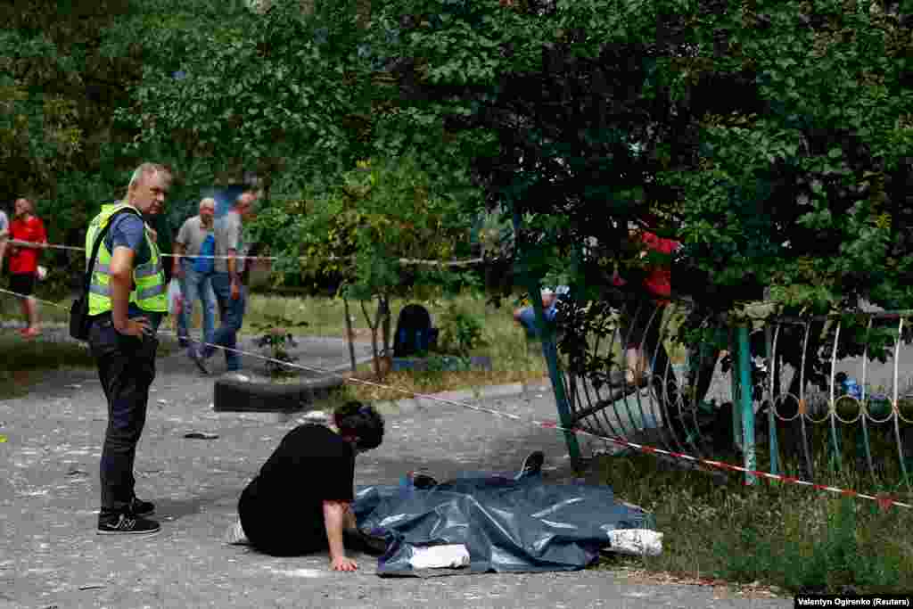 Жінка біля тіл рідних, які загинули під час ракетного обстрілу. Російські війська неодноразово завдавали масованих ударів по столиці від початку повномасштабного вторгнення РФ у лютому 2022 року. Остання масштабна атака на Київ із застосуванням безпілотників і ракет була здійснена у червні 2024 року  