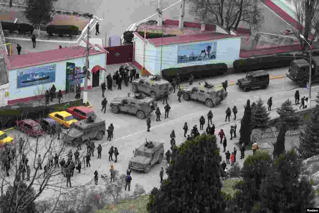 Российские солдаты и техника без опознавательных знаков окружают крымскую пограничную базу в Балаклаве, 1 марта 2014 года. В тот же день пророссийский премьер-министр Крыма обратился к Кремлю с просьбой «оказать помощь в обеспечении мира и спокойствия» в Крыму.  