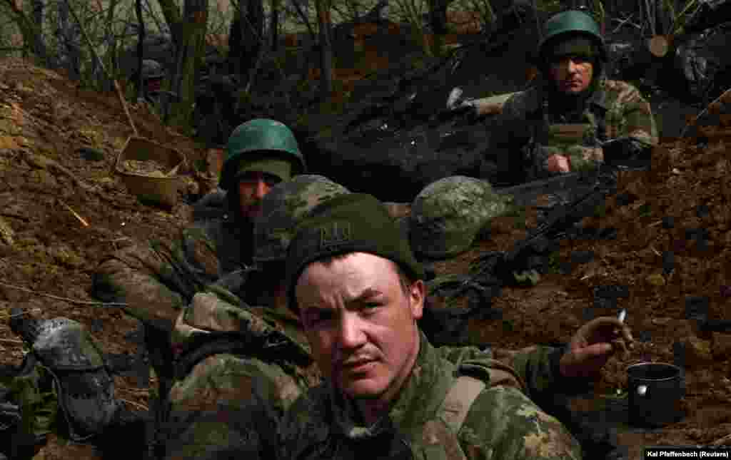 Дощова і холодна погода початку квітня перетворила окопи на рови, заповнені рідкою грязюкою. Попри це, щільний артилерійській вогонь супротивника примушує українських бійців «зариватися під землю». Коротка мить, щоб перевести дух і перекурити. Позиції ЗСУ під Бахмутом, 5 квітня 2023 року