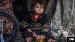 په رفح کې یو بې کوره شوی فلسطینی ماشوم خواړه خوري - پخوانی انځور.
