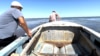 Mukangazi Ibaev (left) and a friend pull a motorboat out to deeper water on the Little Aral Sea on August 22.