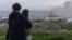 Молодые люди смотрят на пожар, начавшийся в результате российского обстрела Одессы 29 апреля этого года
