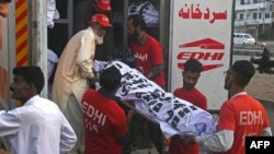 مرستندویه کارکوونکي د حب په ټرافيکي پېښه کې د وژل شویو کسانو جسدونه لېږدوي.