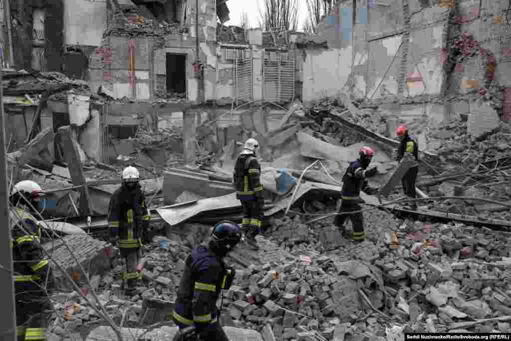 Firefighters pick through the rubble of a building in Kyiv destroyed by a falling Russian missile on March 25, 2024.  