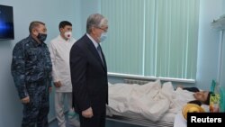 Kazakh President Qasym-Zhomart Toqaev visits a patient in Almaty in January 2022 who was injured during the bloody protests earlier that month.