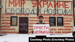 Дмитрий Скурихин с одним из плакатов, из-за которого против него возбудили уголовное дело