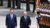 Președintele chinez Xi Jinpin (stânga) și președintele rus Vladimir Putin salută garda de onoare în timpul vizitei liderului rus la Beijing de anul trecut.