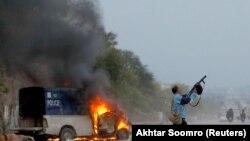 اسلام اباد کې یو سرتېری د مارچ پر ۱۸مه د مظاهرچیانو خورولو لپاره اوښکې بهوونکی ګیس کاروي.