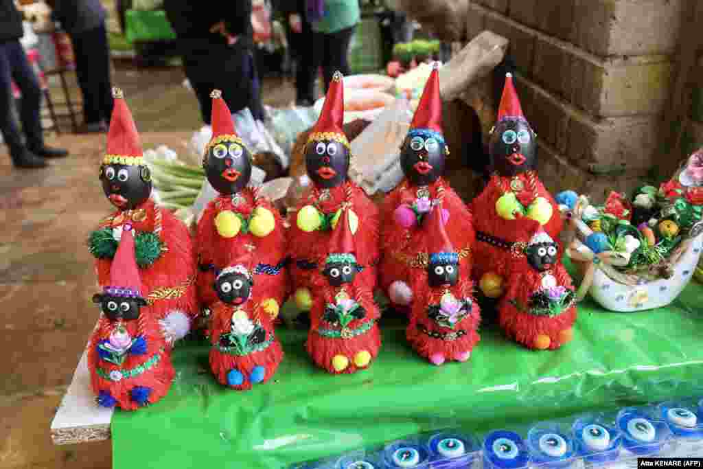 Figures of the fictional folklore character Hajji Firuz, who appears in the streets at the beginning of Norouz, are displayed at a stall in Tehran ahead of the festival.    