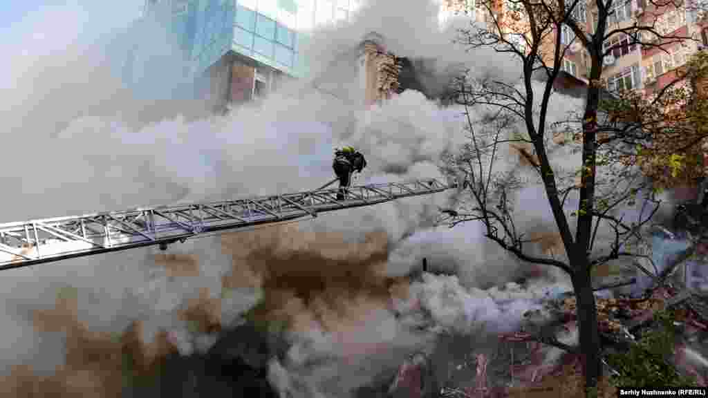 A firefighter battles a blaze after a Shahed suicide drone attack in Kyiv on October 17, 2022. 