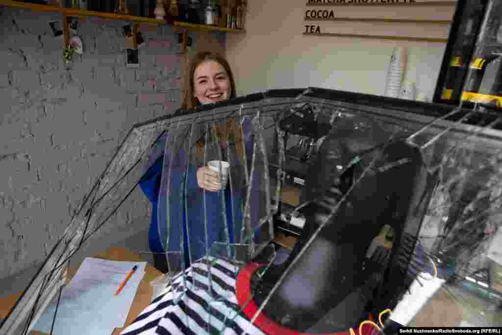 A barista at work inside her explosion-damaged cafe on March 25, 2024 after a Russian missile hit central Kyiv.   