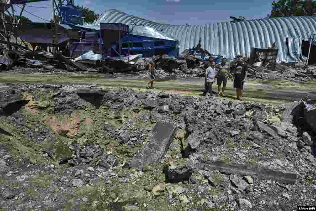 People walk next to a destroyed agricultural storage building.  Kiper said Russia launched Kalibr-type cruise missiles from vessels in the Black Sea that targeted the facilities in Odesa.