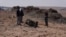 Израильский полицейский и местные жители около обломка ракеты, тяжело ранившей семилетнюю девочку