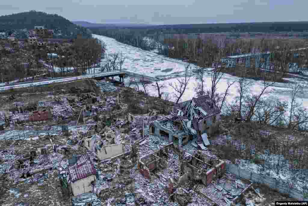 Дома, разрушенные российскими войсками, видны сверху возле взорванного моста через реку Сиверский-Донец в освобожденном селе Богородичное. Украина, 13 января 2023 года. (AP Photo/Evgeniy Maloletka) 