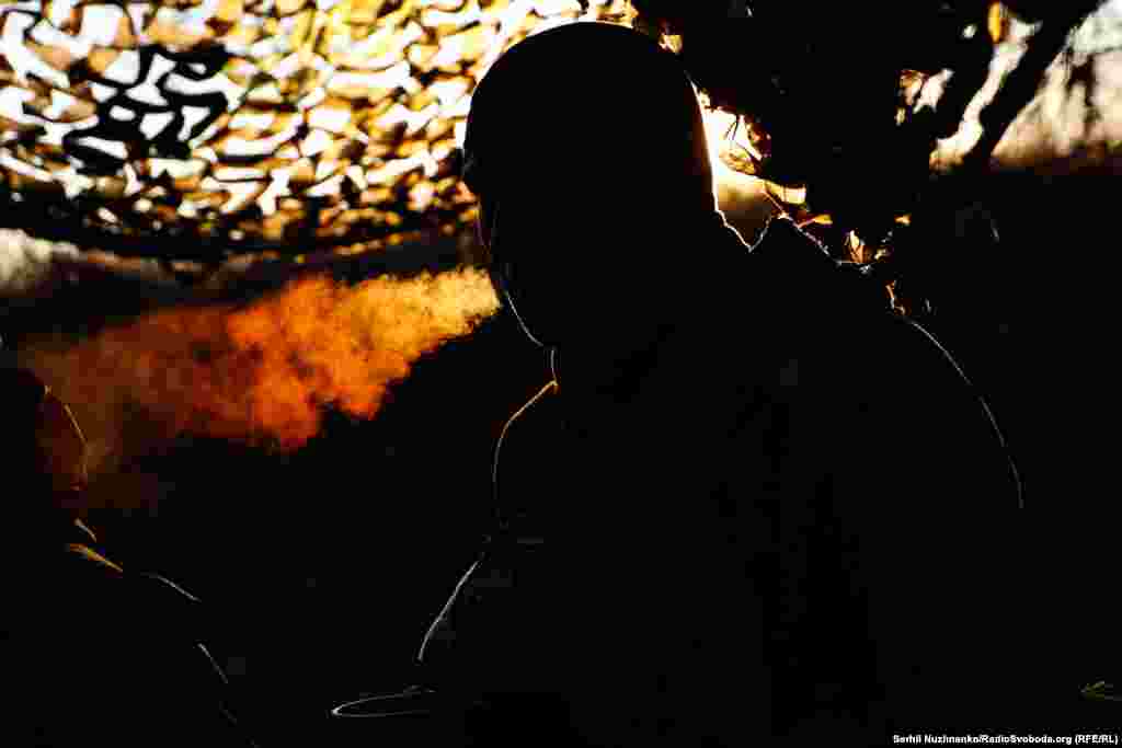 A member of a Ukrainian mortar team pauses for a sunrise cigarette at a position near Bakhmut in December 2023. 