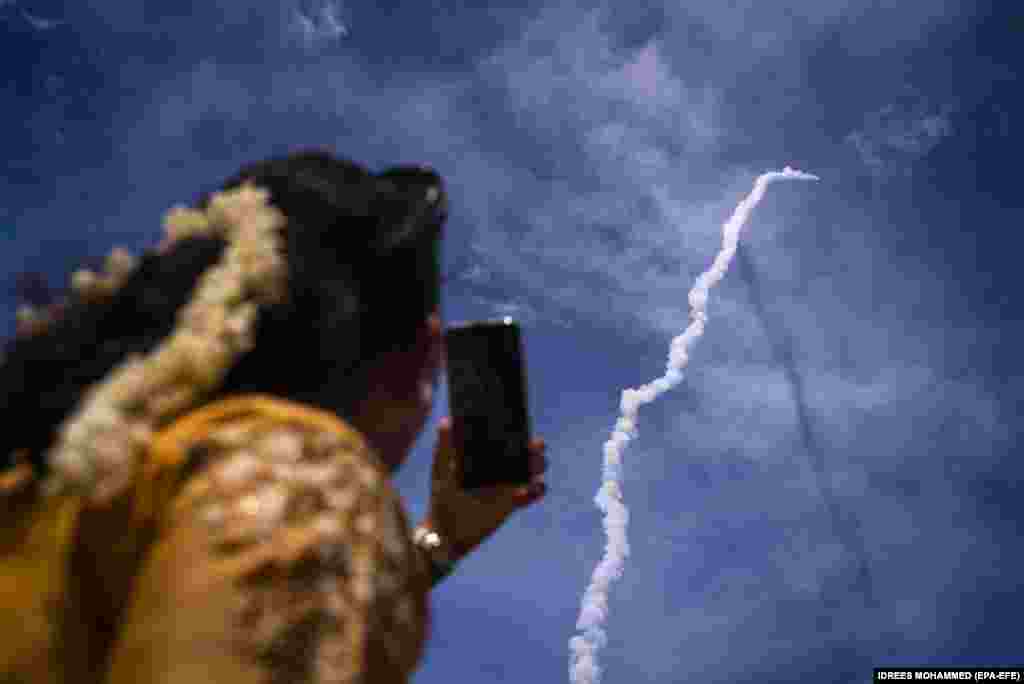 Представитель общественности наблюдает, как Чандраян-3 (Лунный аппарат-3) Индийской организации космических исследований (ISRO) на борту ракеты-носителя Mark-III миссии 4 (LVM3 M4) стартует из Космического центра Сатиш Дхаван в Шрихарикота, южный штат Андхра-Прадеш. Индия, 14 июля 2023 года. Индийское космическое агентство с бюджетом менее 75 миллионов долларов пытается посадить марсоход на Луну и присоединиться к группе стран, в которую входят Соединенные Штаты, бывший Советский Союз и Китай, совершившие успешную мягкую посадку на Луну. (EPA-EFE/IDREES MOHAMMED)