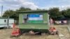 An Uzbek flag hanging at a caravan window in Britain. Most migrant workers live in caravans, shared by up to six people.