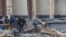Люди расчищают завалы у Харьковской областной администрации на центральной площади