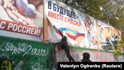 Украинские полицейские срывают российские агитационные щиты в городе после отступления России из Херсона, 16 ноября 2022 года
