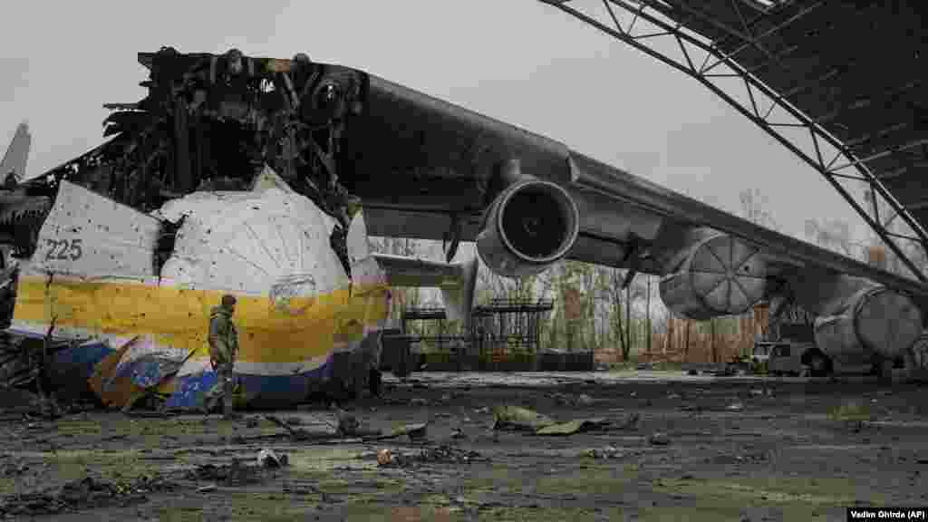 Украинский солдат проходит мимо обломков транспортного самолета Ан-225 «Мрия», 2 апреля 2022 года. «Мрия», самый большой самолет в мире, была уничтожена российским ударом 27 февраля во время боев в аэропорту Антонов в Гостомеле. «Мрия», что означает «мечта», была известна любителям авиации во всем мире.