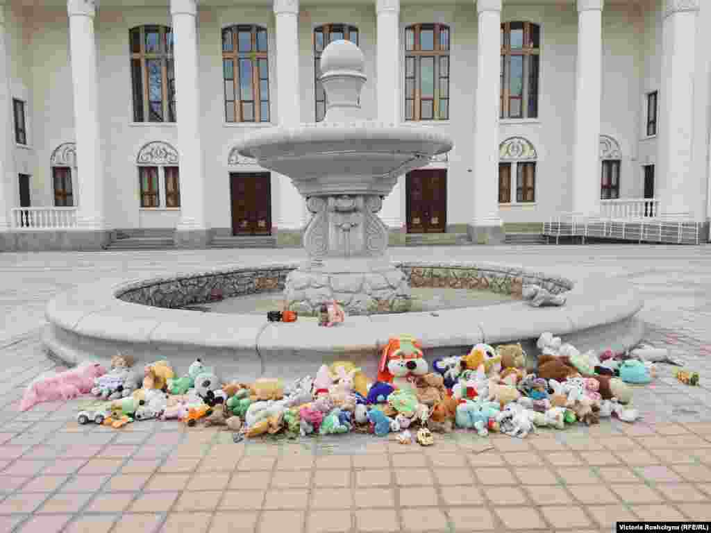 Импровизированный мемориал детям, погибшим во время войны, перед Дворцом культуры в городе Новая Каховка Херсонской области. «Это здание напротив российской комендатуры», – сказал проходивший мимо мужчина. «Они (люди) приносят сюда игрушки, чтобы они (российские военные) видели и помнили»