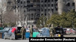 Российские военные проверяют автомобили мирных жителей в Мариуполе, Украина, 20 марта 2022 года