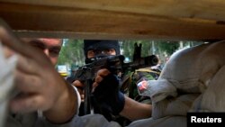 A heavily armed pro-Russian rebel mans a newly erected barricade on the airport road of the eastern Ukrainian city of Donetsk on May 27.
