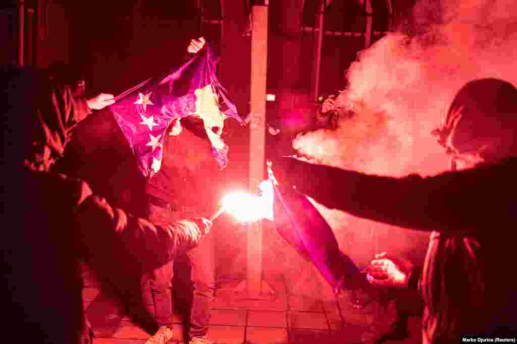 Un protestatar arde un steag al Kosovo la Belgrad. Șeful politicii externe a UE, Josep Borrell, a făcut apel la dezescaladare atât din partea Kosovo, cât și din partea Serbiei, în timp ce președintele sârb Aleksandar Vucic a cerut desfășurarea de trupe sârbe în nordul Kosovo, alimentând temerile privind un nou război.