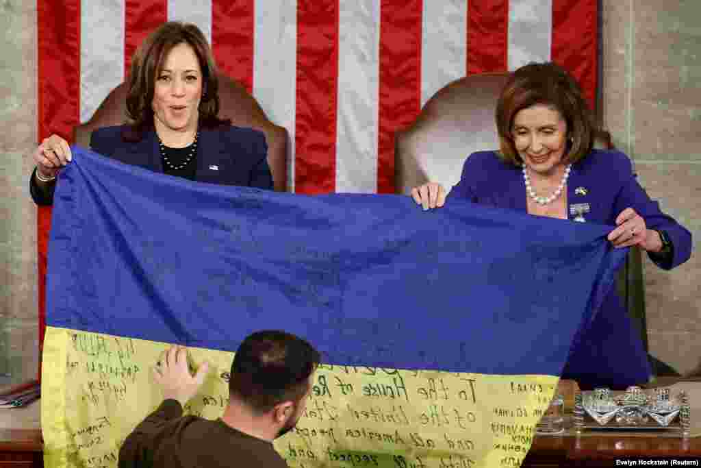 U.S. Vice President Kamala Harris (left) and U.S. House Speaker Nancy Pelosi hold an inscribed Ukrainian flag brought by Zelenskiy from Bakhmut. In his address, Zelenskiy compared the heroism of Ukrainian soldiers defending Bakhmut to that shown by U.S. troops fighting Adolf Hitler’s troops in the Battle of the Bulge in 1944, also during the Christmas season. "Bakhmut stands," Zelenskiy said to cheers. "Ukraine holds its lines and will never surrender."