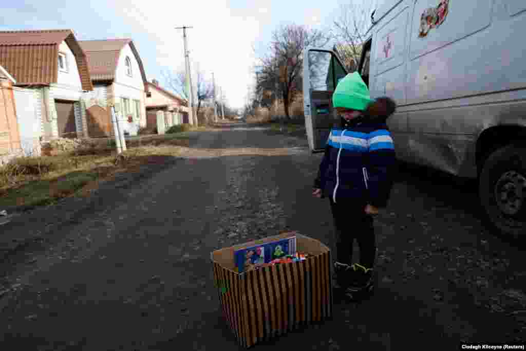 Тем временем 4-летний Тимур рассматривает коробку с его подарками.    