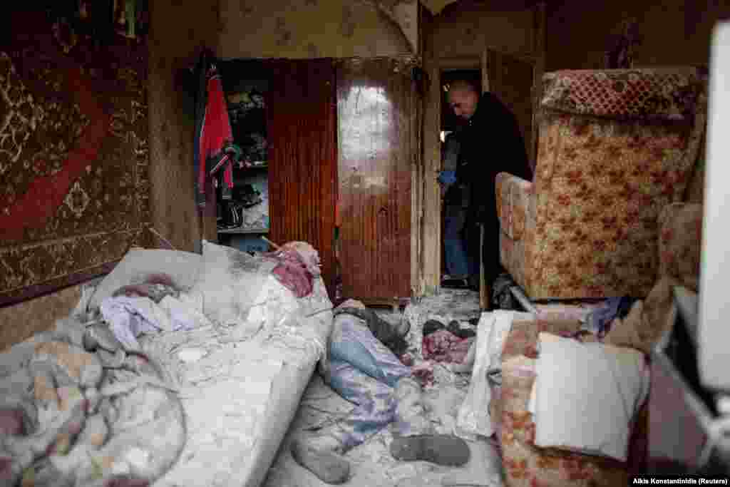 Представник  ДСНС України стоїть над тілом 41-річного жителя, який загинув у своїй квартирі внаслідок російського обстрілу. Харків, 13 квітня 2022 року