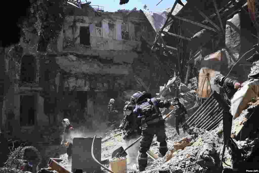 Employees from the local separatist-controlled government clear rubble from the Mariupol theater on May 12. An AP investigation estimated that 600 civilians died when Russia attacked the theater while it was being used as a bomb shelter.  