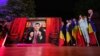 George Simion (AUR) transmite mesajul victoriei în primul tur al alegerilor prezidențiale, de la un birou având în fundal o bibliotecă cu icoane. Nu a venit în fața jurnaliștilor și a colegilor. Cuvintele sale au fost înregistrate și difuzate la ora exit-poll-urilor.
