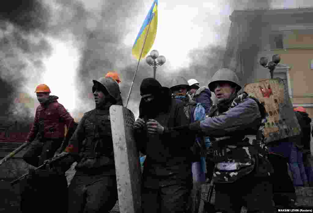 Участники «Революции достоинства» отводят бойца спецназа с Майдана Независимости в Киеве, 20 февраля 2014 года