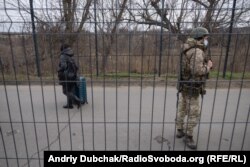 Жінка з валізою рухається в бік підконтрольної Україні території на КПВВ «Станиця Луганська», 26 листопада 2021 року