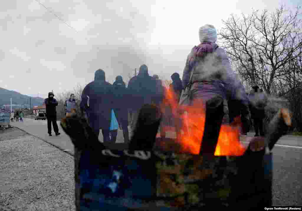 Sârbii kosovari se încălzesc în apropierea satului Rudine, pe 13 decembrie. Prim-ministrul kosovar Albin Kurti a declarat marți că Pristina va depune săptămâna aceasta cererea de aderare la Uniunea Europeană, un proces care se așteaptă să dureze ani, dacă nu chiar decenii, și care depinde de normalizarea relațiilor cu Serbia.