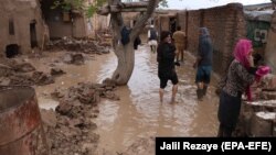 Afghans survey their damaged houses after seasonal floods in Herat on March 29.