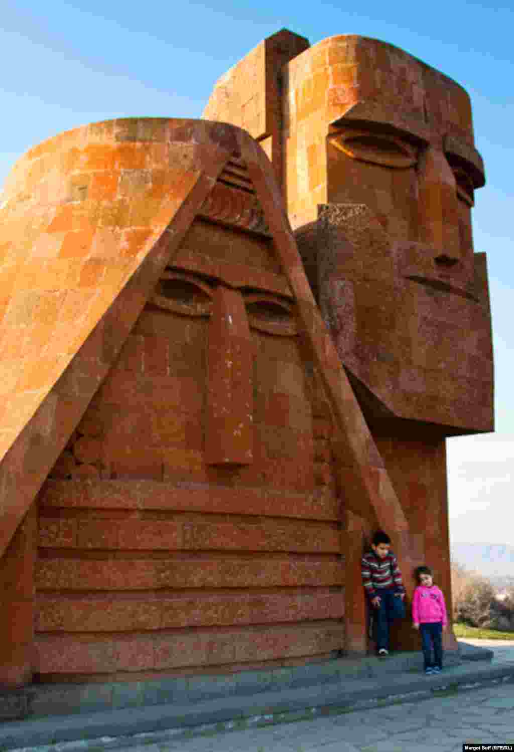 Kids pose by a monument titled "We Are Our Mountains," informally known as "Grandma and Grandpa." The 1967 sculpture is recognized as a symbol of Nagorno-Karabakh.