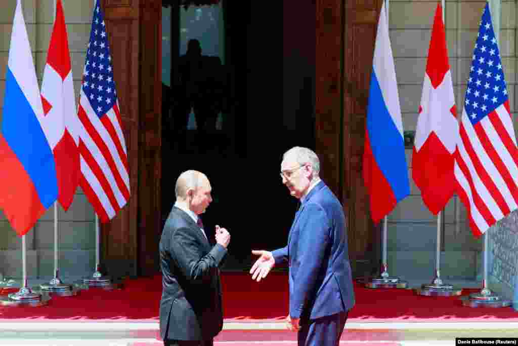 Swiss President Guy Parmelin greets Russia's President Vladimir Putin before he enters the villa. 