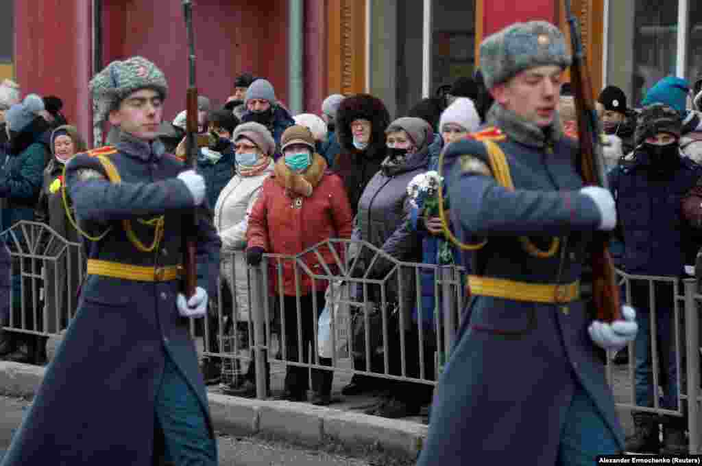Жителі Донецька спостерігають за церемонією вшанування пам’яті жертв обстрілу 22 січня 2015 року тролейбусної зупинки «Донецькгірмаш». Українська сторона стверджує, що обстріл влаштували самі проросійські бойовики для дискредитації ЗСУ, а проросійське угруповання «ДНР» звинувачує Україну. Непідконтрольний Донецьк, ОРДЛО. 22 січня 2022 року