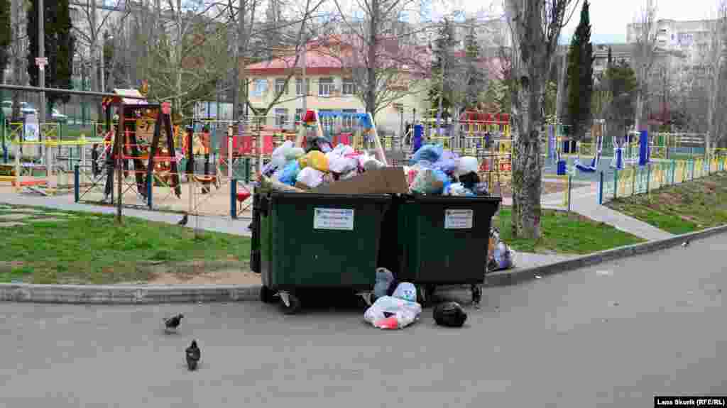 Во дворе этого же дома у детской и спортивной площадок – переполненные контейнеры для мусора