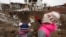 Дети рядом с воронкой после российского ракетного удара. Город Глеваха под Киевом, 26 января 2023 года