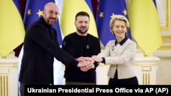 Ukrainian President Volodymyr Zelenskiy (center) European Commission President Ursula von der Leyen (right) and European Council President Charles Michel shake hands during their EU-Ukraine summit in Kyiv on February 3.