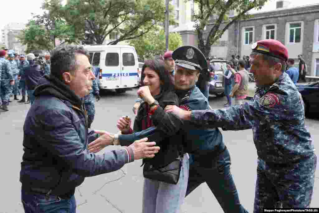 A woman is detained by police in Yerevan on May 3.  The prime minister's political allies accuse the opposition of exploiting the Karabakh issue in a bid to seize power. They point to recent elections that reinstated the ruling party after the large-scale conflict with Azerbaijan in 2020. 