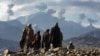 Anti-Taliban Afghan fighters watch several explosions from U.S. bombings in the Tora Bora Mountains of Afghanistan on December 16, 2001.